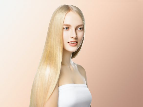 Smooth long blond hair woman natural make up healthy skin. On beige.